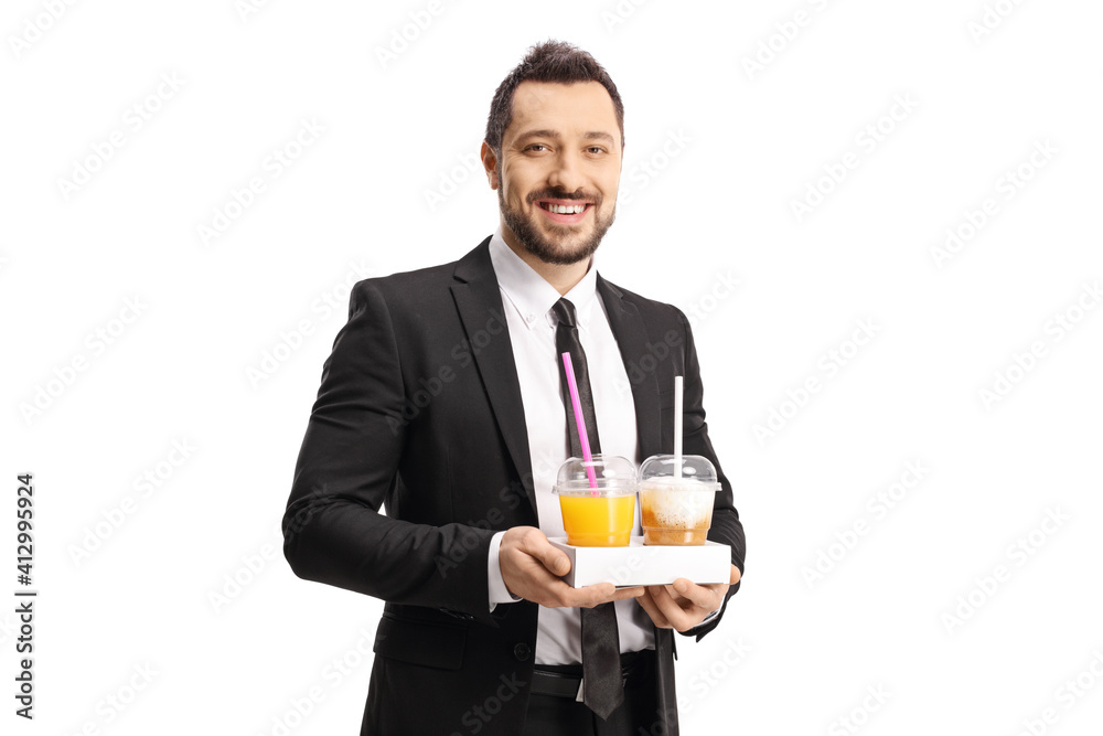 Young professional man in a suit carrying takeaway coffee and orange juice Young professional man in a suit carrying takeaway coffee and orange juice