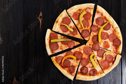 Tasty pepperoni pizza on wood background. Top view of hot pepperoni pizza. With copy space. Flat lay. Banner