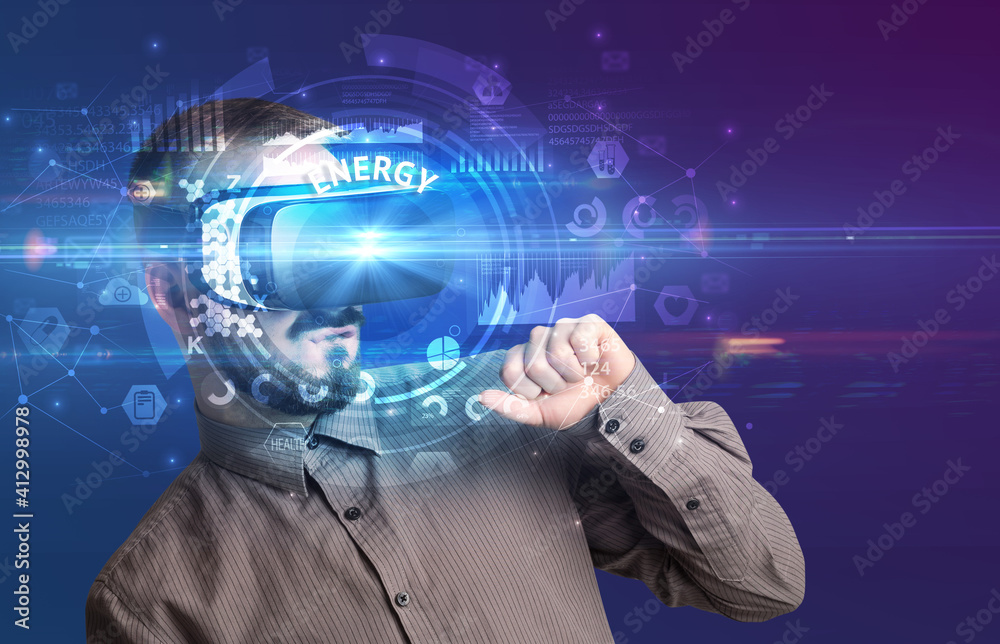Businessman looking through Virtual Reality glasses with ENERGY inscription, innovative technology concept Businessman looking through Virtual Reality glasses with ENERGY inscription, innovative technology concept
