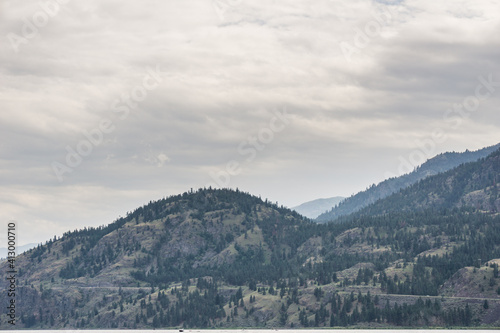 mountains in Okanagan valley and cloudy sky.