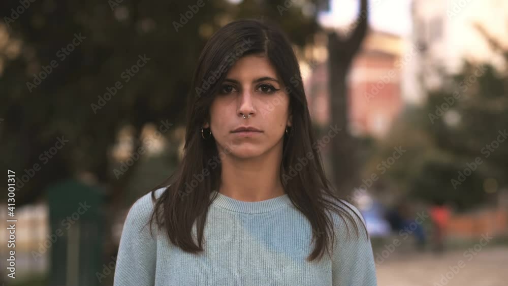 beauty, youth - serious woman changes expression and smiles at camera