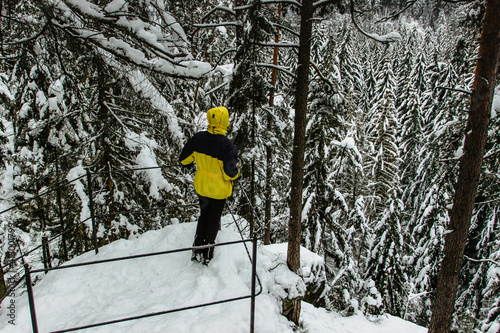 Person enjoying winter view from Kyjov clifftop,romantic Krinice River canyon near Krasna Lipa in Bohemian Switzerland National Park,Czech Republic.Adventure active lifestyle.Cold frosty day in nature photo