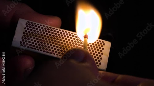 Close-up of fingers striking a safety match, slow motion