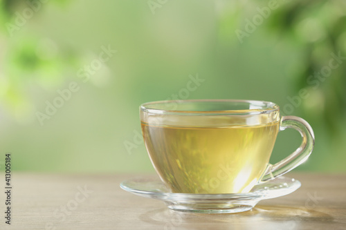 Glass cup of fresh herbal tea on table. Space for text