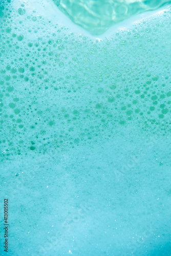 water foam and bubbles of blue color as background. cosmetology concept