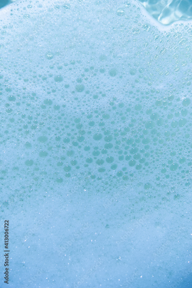 water foam and bubbles of blue color as background. cosmetology concept