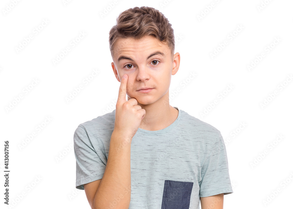 Handsome teen boy showing his eye, isolated on white background Handsome teen boy showing his eye, isolated on white background