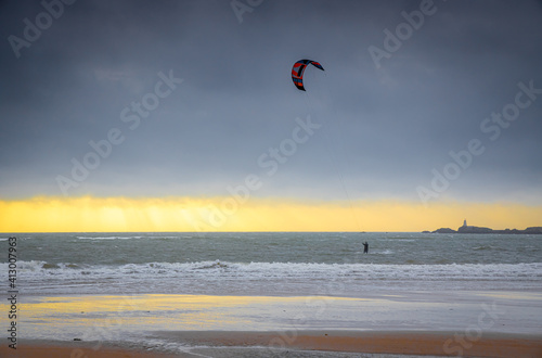 A kiteboarder harnessing the power of the wind with a large controllable power kite, seaside photo