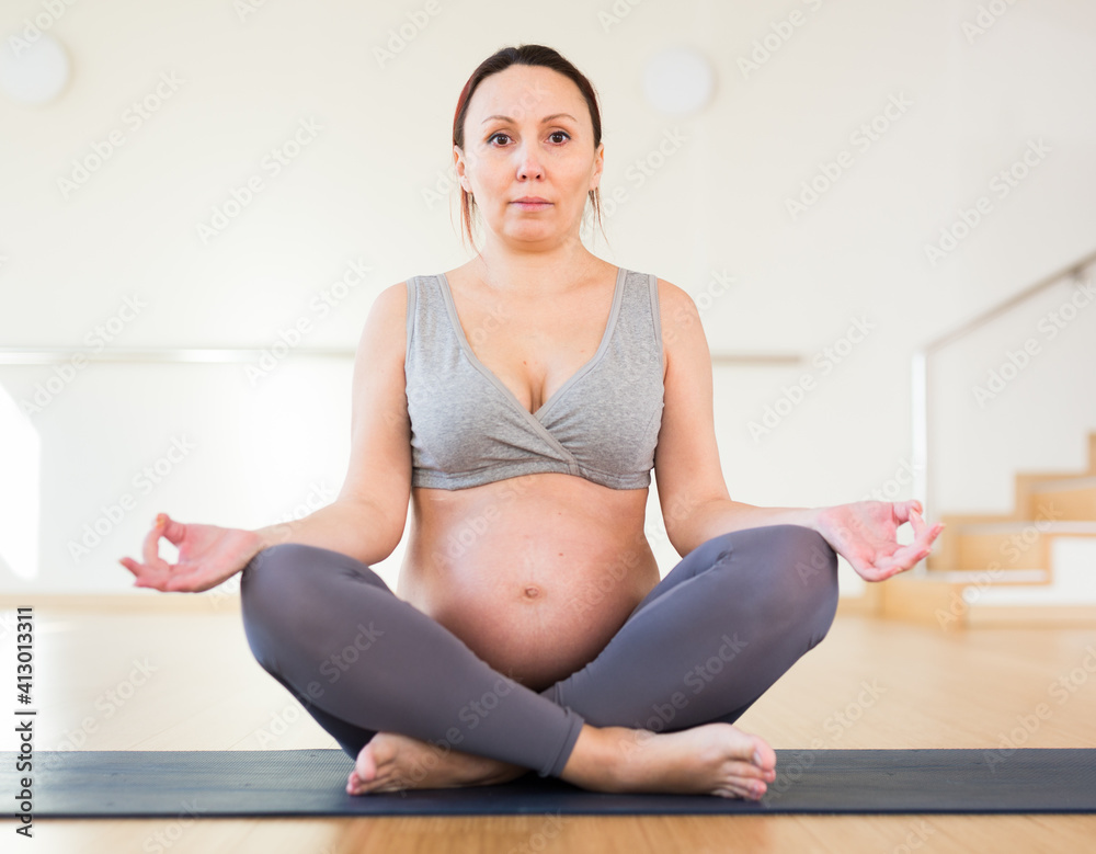 Pregnant woman is engaged in yoga. Easy Pose or Sukhasana
