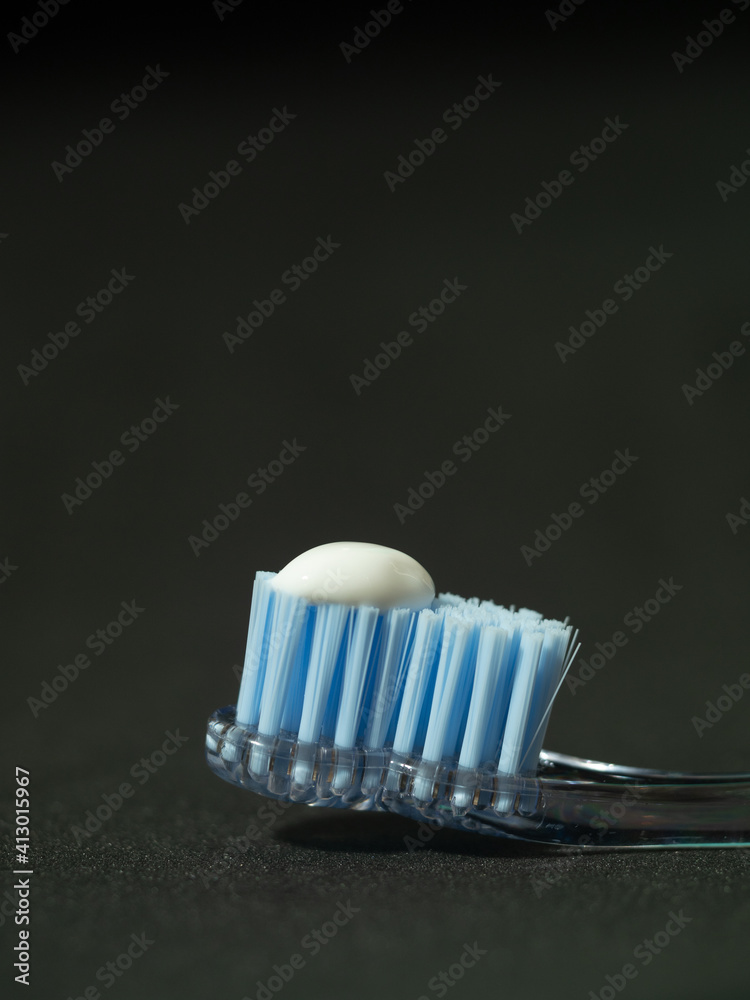 macro photograph of toothbrush with the right amount of toothpaste equivalent to the size of a pea on black background. concept of proper tooth cleaning macro photograph of toothbrush with the right amount of toothpaste equivalent to the size of a pea on black background. concept of proper tooth cleaning