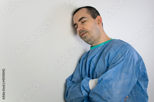 young male surgeon stand wall relax sleep health care help people exhausted © kirill
