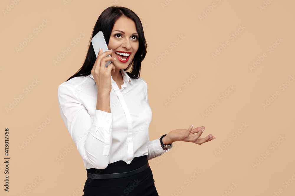 Surprised young modern business woman talk on smartphone over beige background. Surprised young modern business woman talk on smartphone over beige background.