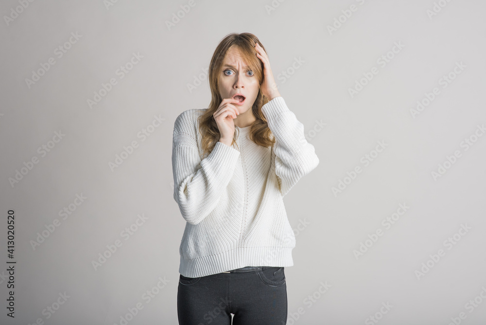 Beautiful young girl on a white background in the studio shocked and surprised Beautiful young girl on a white background in the studio shocked and surprised