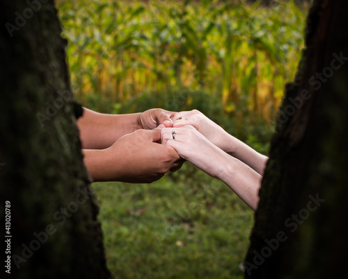 An engaged couple holding hands with focus on the ring