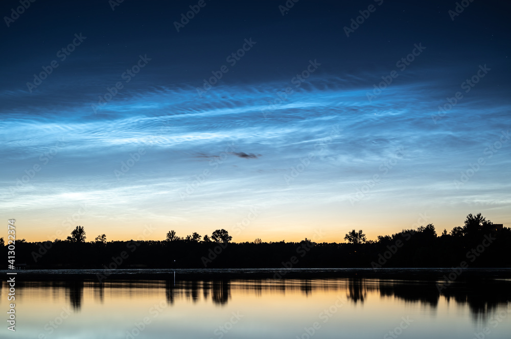 Scenic noctilucent clouds at night sky