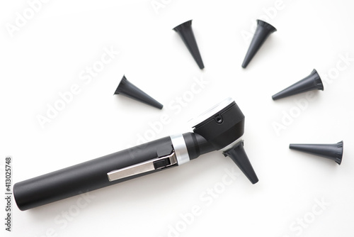 On table is an otoscope with replaceable attachments