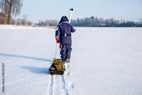 The fisherman goes to the place of ice fishing. Ice fishing concert. photo