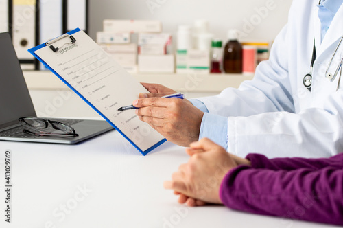Shot of a confident male doctor showing test results to a patient inside of a hospital during the day