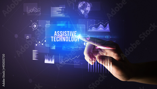 Hand touching ASSISTIVE TECHNOLOGY inscription, new business technology concept