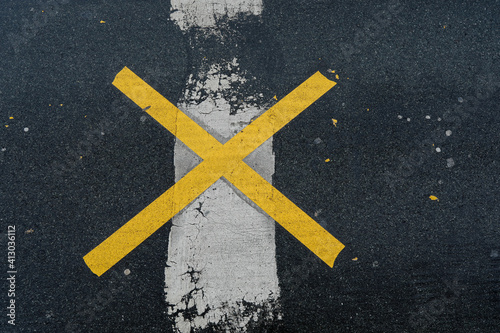 Yellow road mark cross like an x ​​with white line on the road, no person,  vertical format, space for text