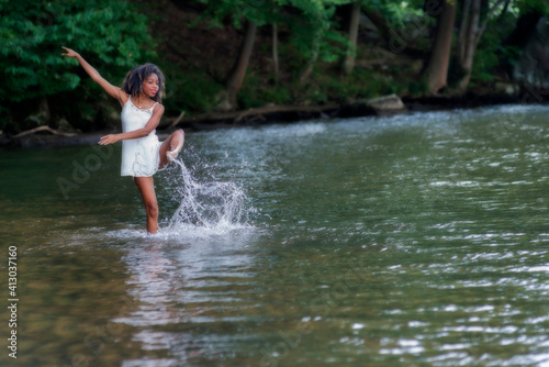 Fototapeta Naklejka Na Ścianę i Meble -  Woman  at lake on swing, large boulder, and in water