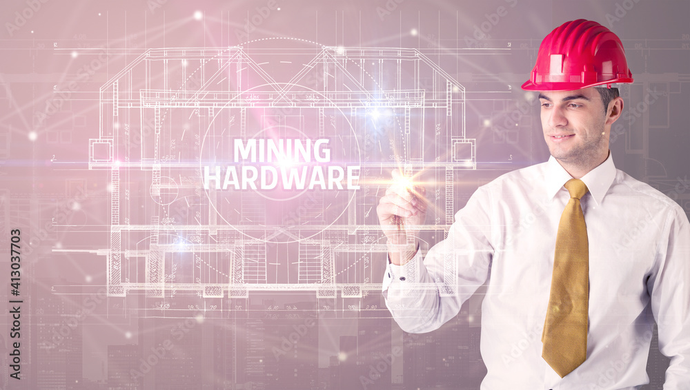 Handsome architect with helmet drawing MINING HARDWARE inscription, new technology concept Handsome architect with helmet drawing MINING HARDWARE inscription, new technology concept