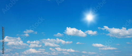 Blue sky with clouds and sun.