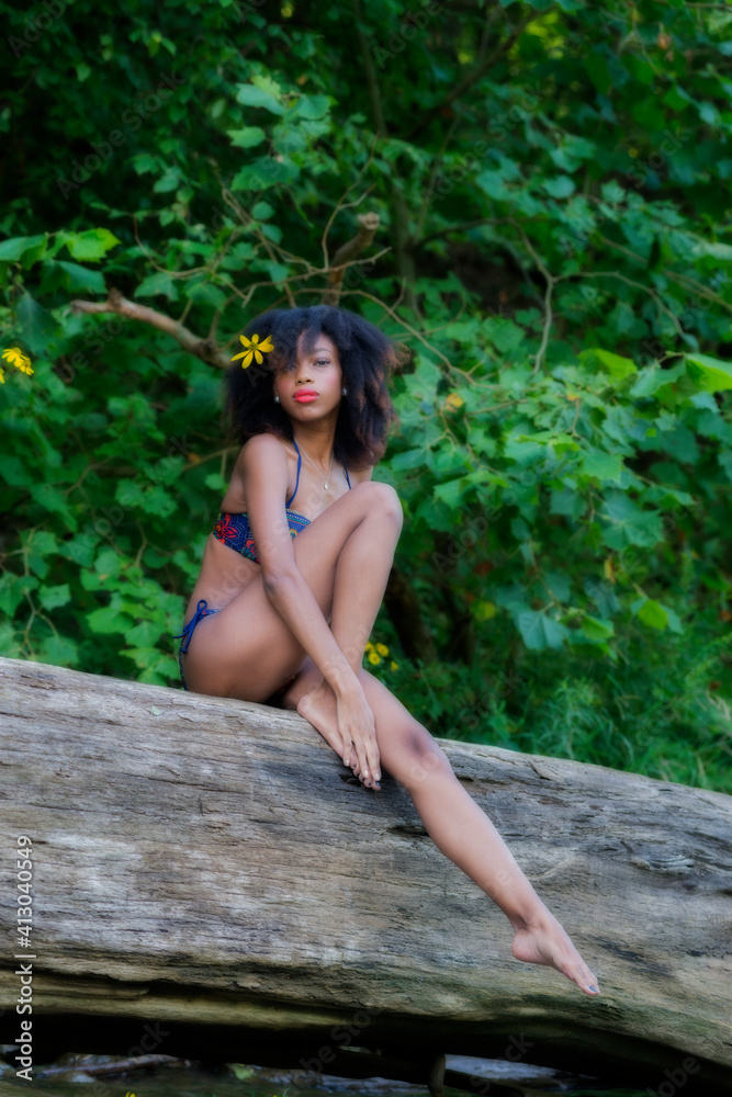 Model in nature posing on log with flowers Model in nature posing on log with flowers