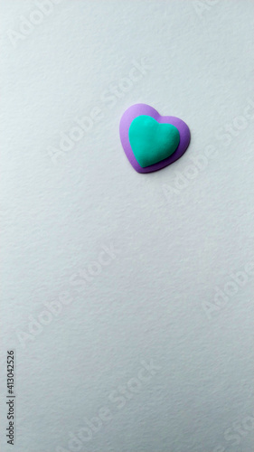 two hearts of turquoise and violet colors of a light textured background