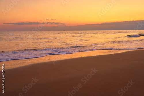 Sandy tropical beach at sunset as a backdrop.