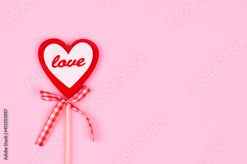 Red heart with a word LOVE on pink background with copyspace. Design for greeting card - Mother's Day, Women Day, 8 March or Valentines Day concept, selective focus