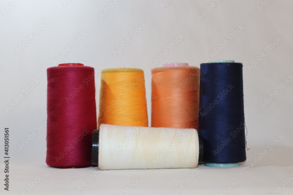 colored thread cones on white background colored thread cones on white background