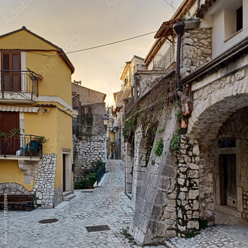 A narrow street between the old houses of Guardia Sanframondi, a medieval village in the province of Salerno, Italy. photo