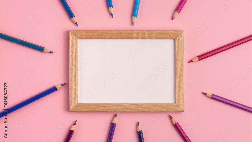 Stop motion animation mockup of wooden frame and pencils around it on pink background. Flat lay top view. Education template back to school and online study concept with copy space