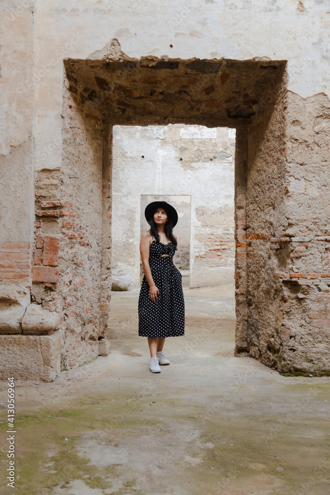 Hispanic young woman on vacation visiting famous ancient ruins - young female traveler enjoying her vacation in Antigua Guatemala