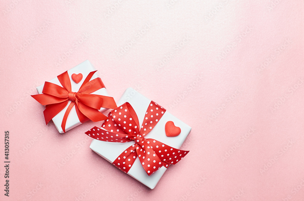 Valentines day gift boxes with red hearts on pink background