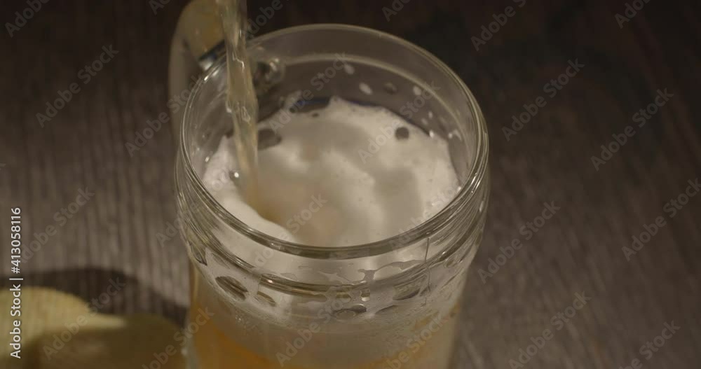 Alcoholic beer. Pouring a cold drink into a glass where the beer foam rises and fills the glass with bubbles and gold color. Close-up of 4K slow motion video Alcoholic beer. Pouring a cold drink into a glass where the beer foam rises and fills the glass with bubbles and gold color. Close-up of 4K slow motion video