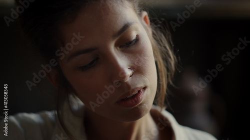 Focused woman examining something in workshop. Girl touching something in studio © stockbusters