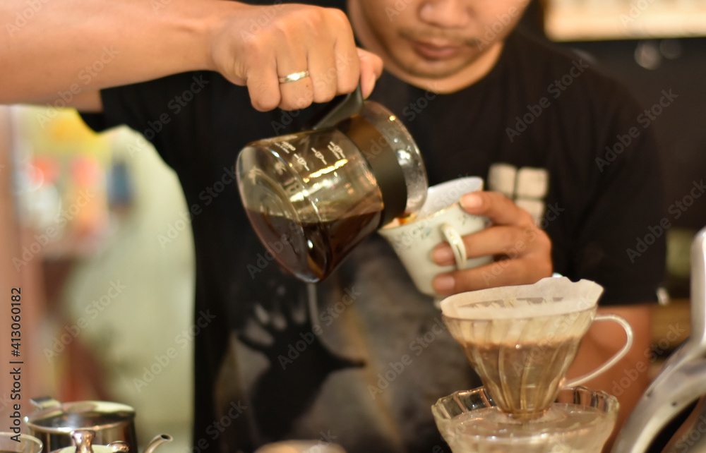 Barista cafe Prepare espresso and vietnam coffee drinks at the coffee shop. portrait of a coffee shop employee making coffee at the bar. the process of making warm drinks with a vintage color concept