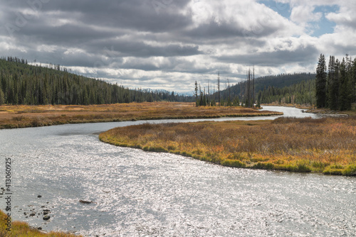 autumn view of sun shining on lewis river of yellowstone national park photo