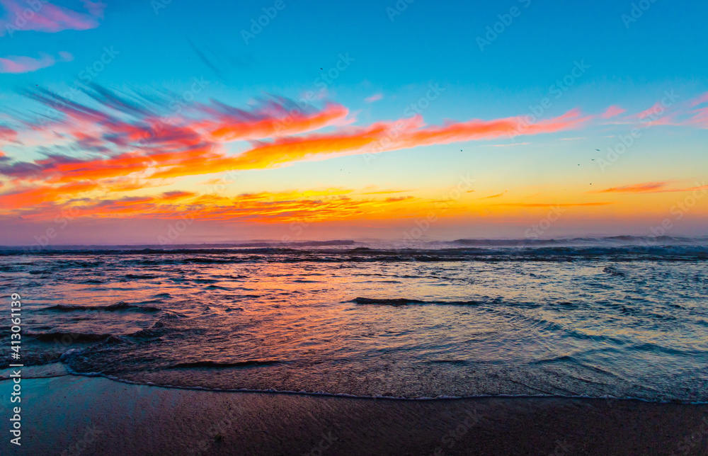 Sea landscape on sunset or sunrise with ocean waves and orange colorful clouds in sky. Concept of vacation on beach, free time, travel, summer, disconnecting from routine and relaxing. Sea landscape on sunset or sunrise with ocean waves and orange colorful clouds in sky. Concept of vacation on beach, free time, travel, summer, disconnecting from routine and relaxing.