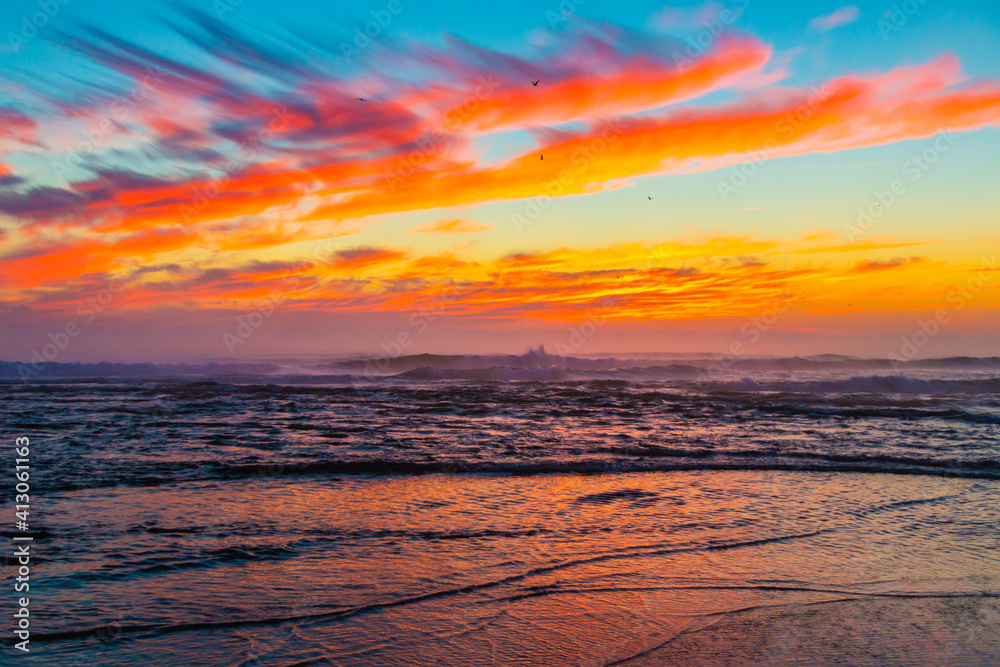 Obraz premium Sea landscape on sunset or sunrise with ocean waves and orange colorful clouds in sky. Concept of vacation on beach, free time, travel, summer, disconnecting from routine and relaxing.