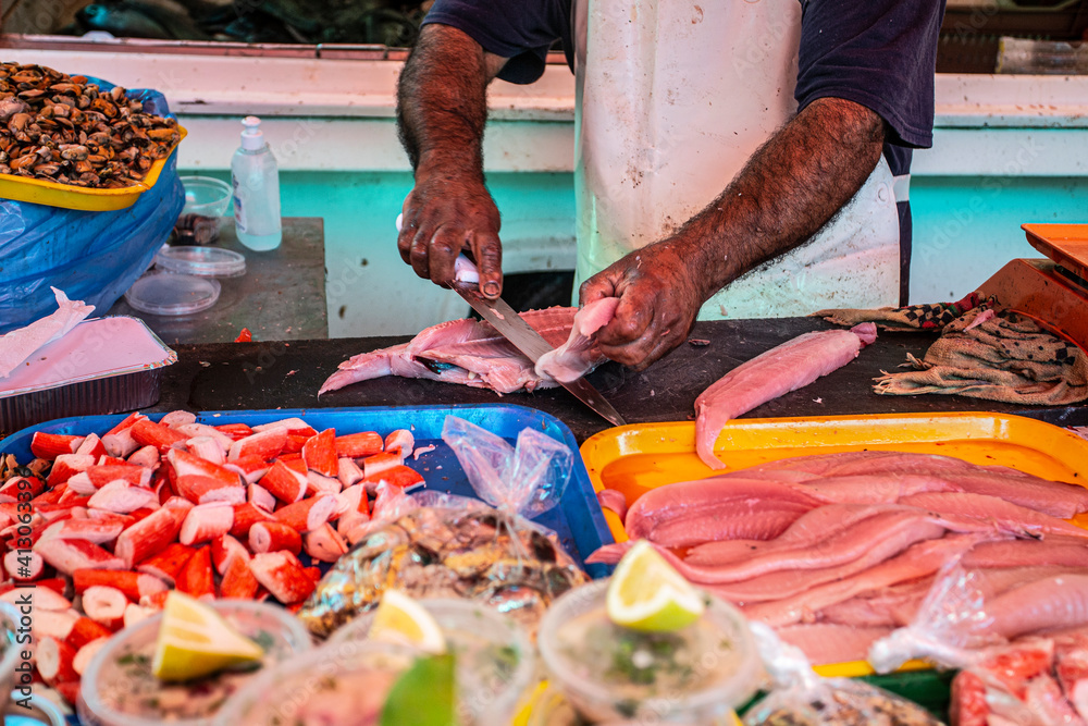 Hands of a man cutting fish in a market