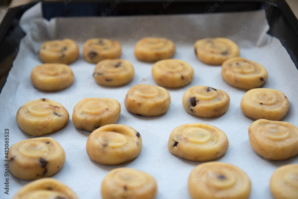 shaped, ready-to-bake dough close-up on tray. Adult woman bakes delicious and crunchy cookies in pandemic shaped, ready-to-bake dough close-up on tray. Adult woman bakes delicious and crunchy cookies in pandemic