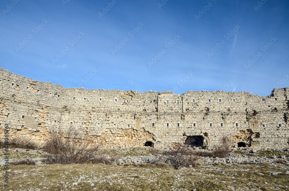 The walls of the old ruined castle. The ruins of a medieval fortress. Medieval fortified city.  