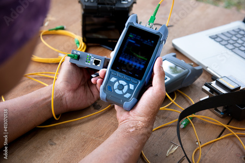 master's hands with optical fiber tester, OTDR meter