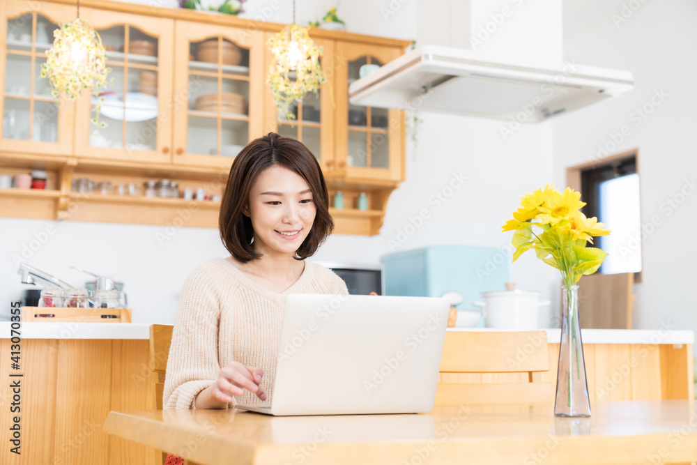 部屋でラップトップコンピューターを見る女性 部屋でラップトップコンピューターを見る女性