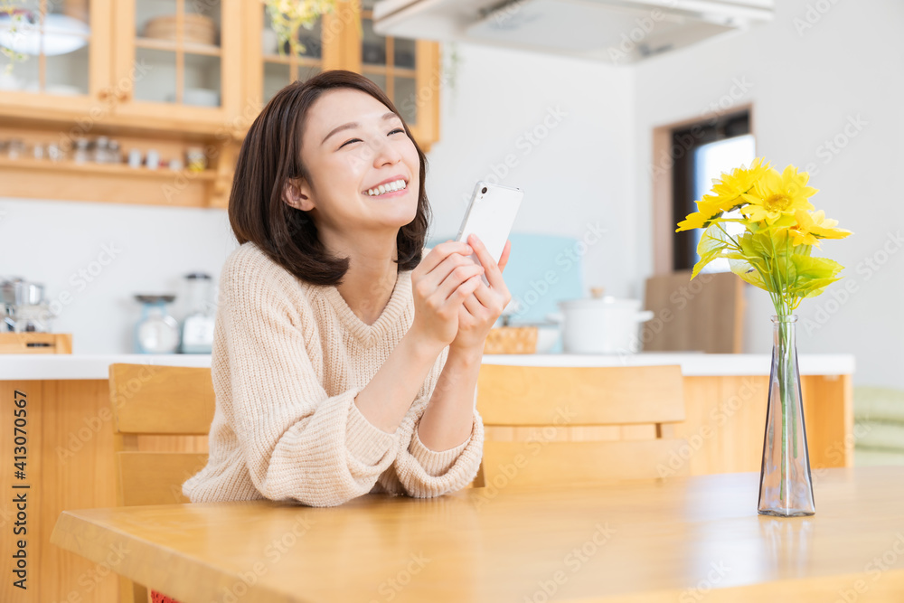 部屋でスマホを見る女性 部屋でスマホを見る女性
