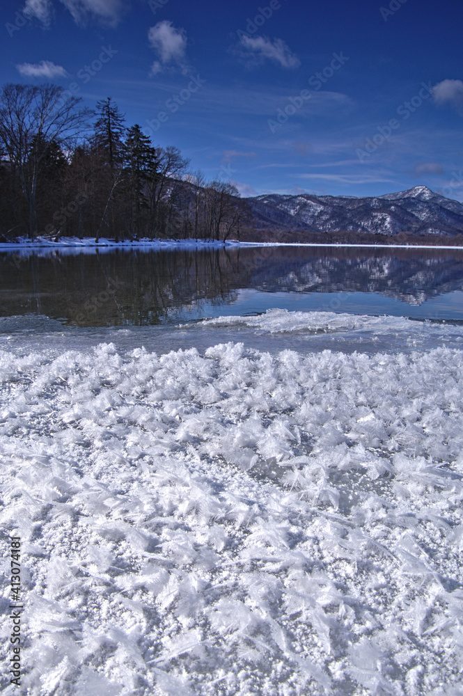 Obraz premium 冬の湖のフロストフラワーと白銀の山脈。北海道の屈斜路湖。