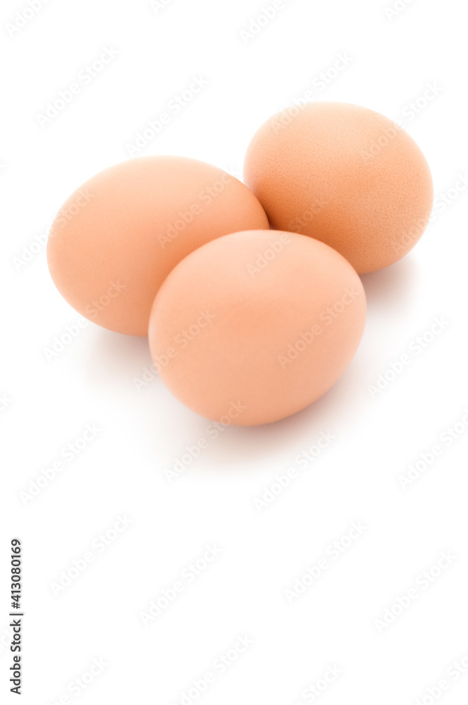 Tres huevos morenos sobre fondo blanco Tres huevos morenos sobre fondo blanco